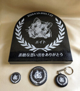 エイトの石彫エンブレムと缶バッジ